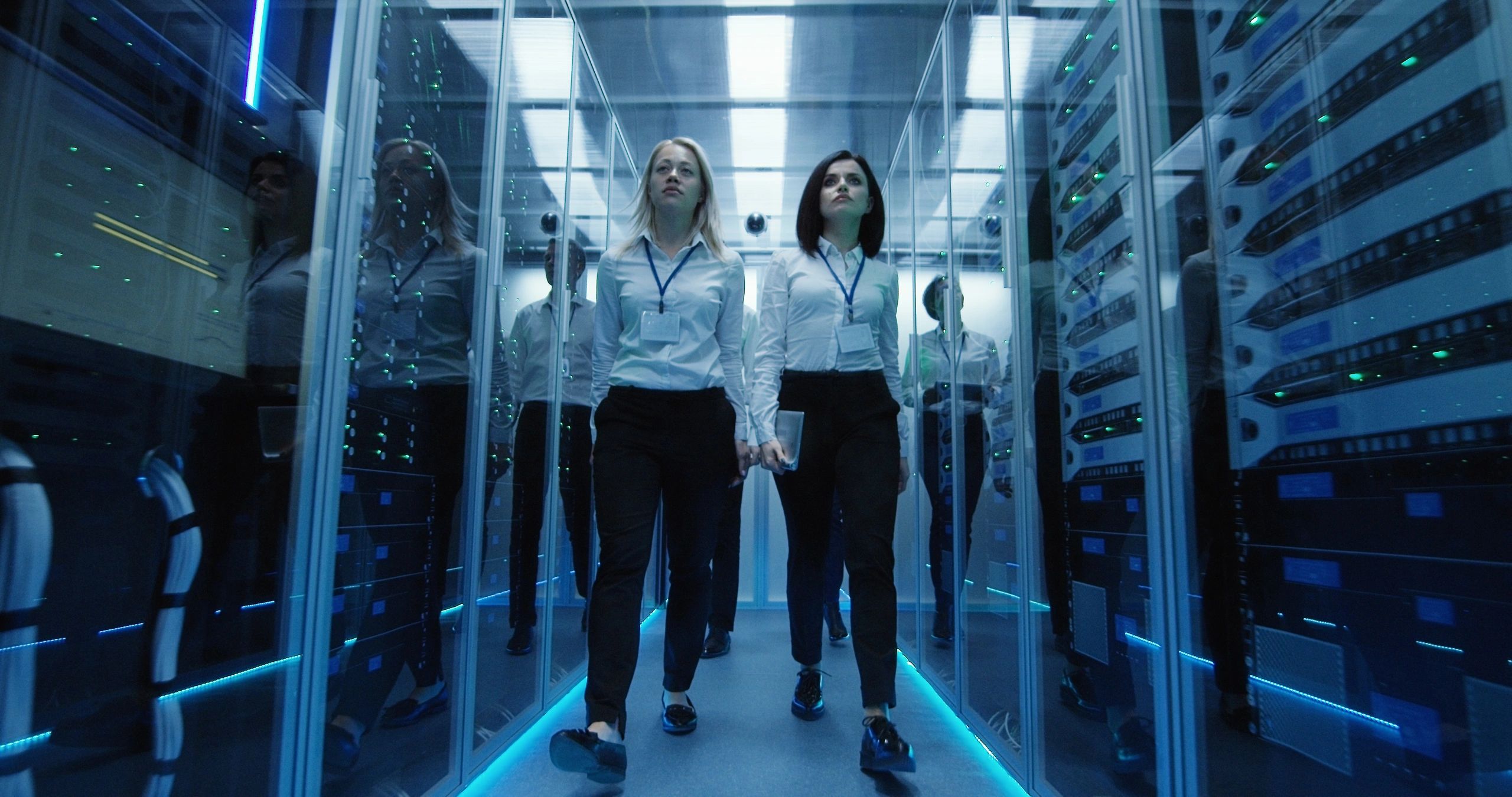 Workers moving through server infrastructure in a data centre